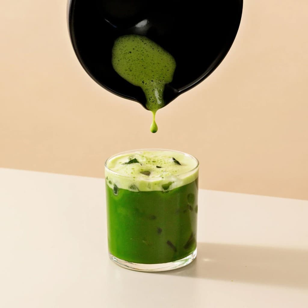 Matcha being poured into a glass over ice